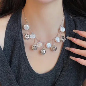 Detailaufnahme einer eleganten Perlen- und Silberanhänger-Halskette an einem Modell.