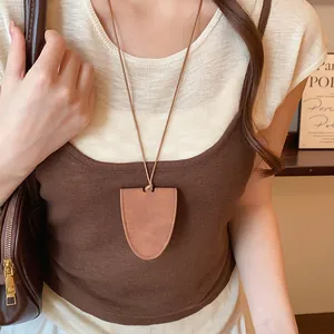 Close-up of a stylish brown shield-shaped leather pendant necklace for a minimalist look