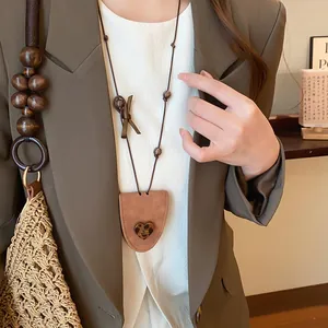 Detail view of Korean style brown leather triangle glasses clip necklace with leopard heart.