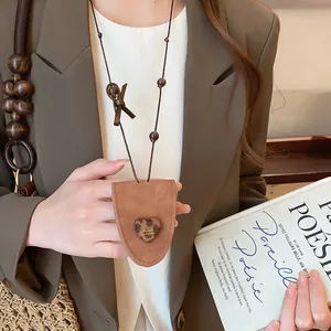 Close-up detail of a brown faux-leather glasses clip necklace featuring a leopard heart