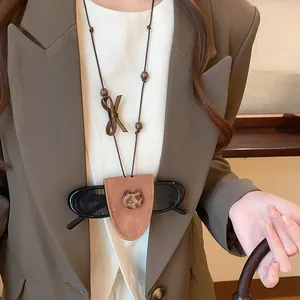 Close-up of brown triangular glasses holder necklace with leopard print cat detail