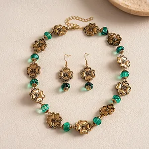 Vintage bronze necklace and earrings set with green resin beads and textured flower charms.