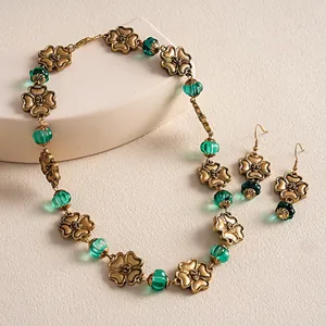 Detail of vintage gold flower necklace and earrings with green fluted resin beads.