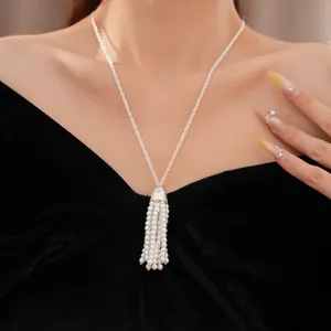 Elegante Pullover-Halskette mit Perlenquasten, detailgetreu am Model getragen.