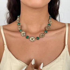 Close-up detail of vintage gold-tone flower necklace with emerald green resin beads