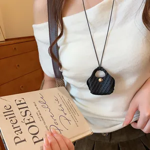 Elegant unique mini woven bag pendant necklace shown as a long sweater chain accessory