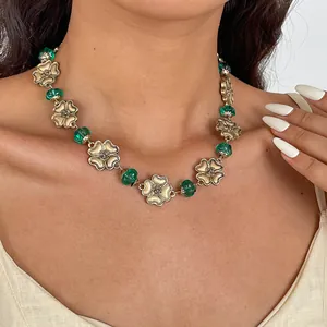 Detailed view of a vintage gold flower necklace featuring green resin beads for women