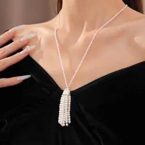 Nahaufnahme einer eleganten weißen Perlen-Quasten-Halskette an einem schwarzen Samtkleid