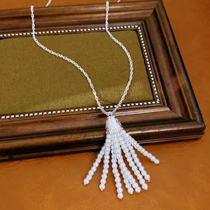 Nahaufnahme einer eleganten Perlen-Quasten-Halskette mit filigraner Silberkette.