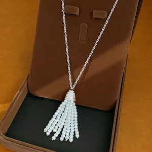 Detailaufnahme einer eleganten weißen Perlen-Quasten-Halskette in brauner Samt-Box