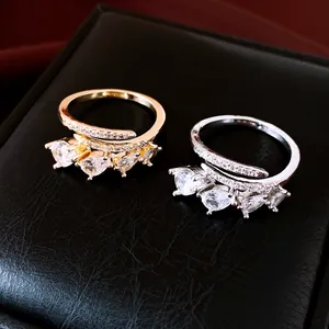 Close-up of gold and silver open rings with elegant pear-shaped zircons on jewelry box
