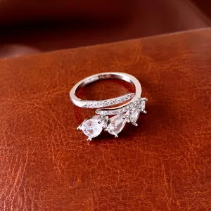 Close-up detail of minimalist silver open ring featuring three sparkling pear-shaped zircons