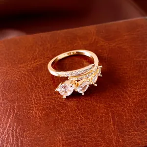 Close-up of elegant gold-tone open ring featuring three sparkling pear-cut cubic zirconia stones.