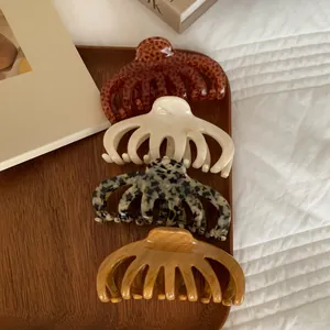 Close-up of four large acrylic hair claw clips in tortoiseshell and leopard patterns