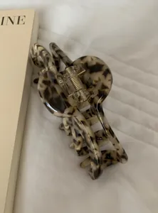 Detail view of a stylish tortoiseshell pattern acrylic hair claw clip for women's hair.