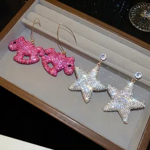 Sprankelende strass paard en ster druppel oorbellen in een luxe sieradendisplay