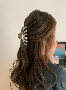 Stylish large acrylic hair claw clip with brown leopard pattern shown on model's hair