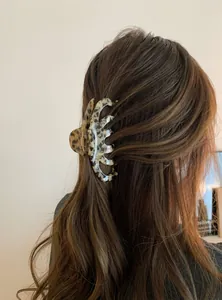 Large tortoiseshell leopard print hair claw clip styled on a model half-up hair.