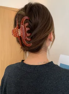 Close-up of a large tortoiseshell acrylic hair claw clip used in a model's hair updo