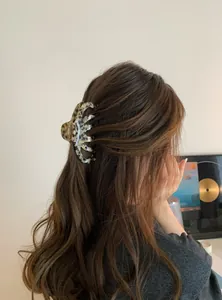 Large leopard print acrylic hair claw clip shown on long wavy hair from a back view.