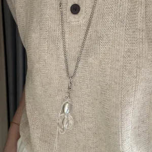 Detailansicht einer koreanischen Quasten-Halskette auf einem beigen Pullover