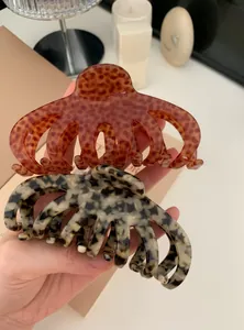 Detail showing large acrylic leopard print octopus hair claws in brown and grey color