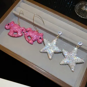 Vue détaillée des boucles d'oreilles en forme de cheval à bascule et d'étoile strass