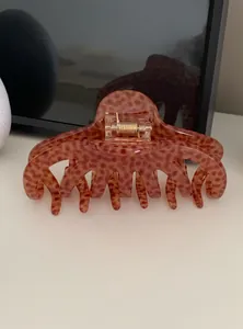 Detailed macro view of a large leopard print acrylic claw clip for stylish hair updos