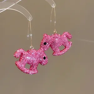 Vue détaillée des boucles d'oreilles cheval en strass rose brillant avec crochets
