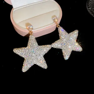 Gros plan de boucles d'oreilles pendantes en étoile avec strass blancs brillants