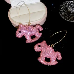 Gros plan de boucles d'oreilles cheval à bascule en strass roses et cristaux étincelants