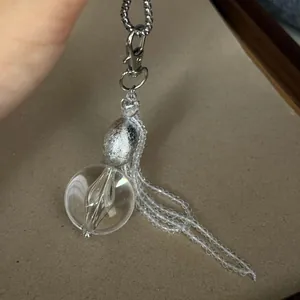 Detaillierte Makroansicht eines Anhängers im koreanischen Stil mit Glaskugel und Perlenquasten.