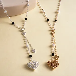 Vintage pearl and rhinestone heart necklace with textured bow detail, silver and gold