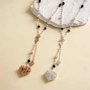 Detail of vintage pearl necklaces with bow and textured heart pendants in gold and silver