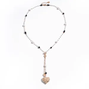 Vintage pearl necklace featuring an engraved gold heart pendant and elegant black accents