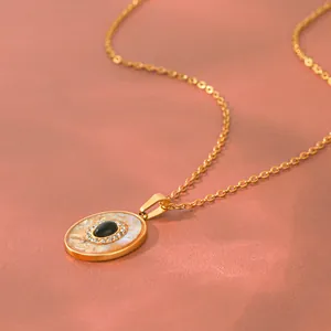 Detail van een obsidiaan hanger met abalone schelp inleg en glanzende kristallen.