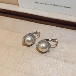 Gedetailleerde opname van vintage zilveren oorbellen met parels en zirkoonsteentjes