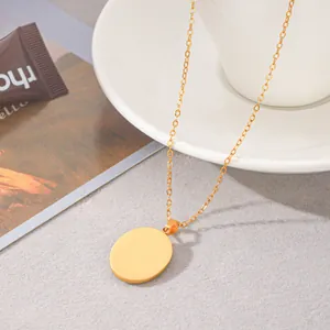 Detailopname van een minimalistische goudkleurige ronde hanger ketting.