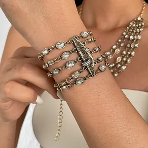 Makro-Detail eines goldenen mehrlagigen Armbands mit funkelnden Strass-Lippenmotiven