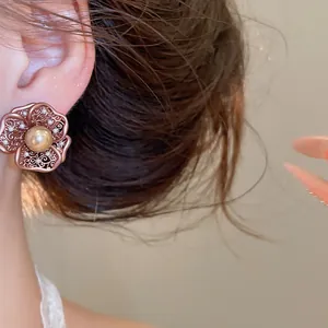 Detailopname van vintage bloemoorbel in Maillard-stijl met een gouden parel.