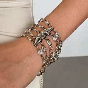 Detailansicht der mehrlagigen Goldhalskette mit strassbesetztem Lippenanhänger-Schmuck.