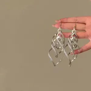 Detailopname van elegante zilveren gedraaide spiraalvormige oorbellen met glanzende afwerking
