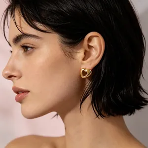 Detailed close-up showing an elegant gold hollow heart stud earring worn by a model