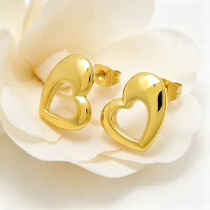 Close-up of gold-plated titanium steel heart stud earrings with a hollow-out polished finish