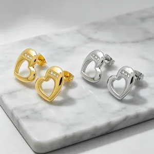 Detailed view of gold and silver heart-shaped stud earrings with sparkling rhinestones
