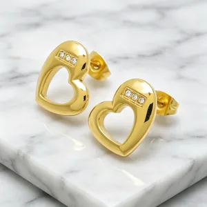 Close-up of gold-plated titanium steel heart stud earrings with cubic zirconia accents
