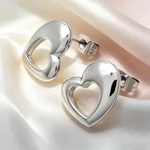 Macro view of minimalist 3D hollow heart stud earrings in smooth titanium steel