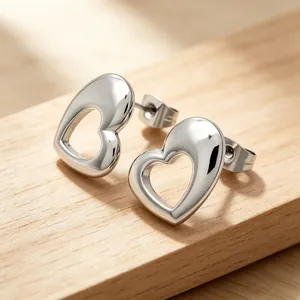 Macro view of polished silver hollow heart-shaped titanium steel stud earrings