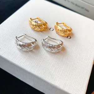 Elegante goud- en zilverkleurige oorringen met geometrisch patroon en fonkelende zirkonia's.