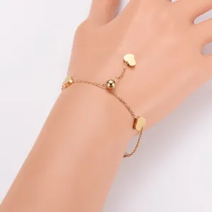 Detailweergave van goudkleurige roestvrijstalen armband met hartjes en schuifsluiting